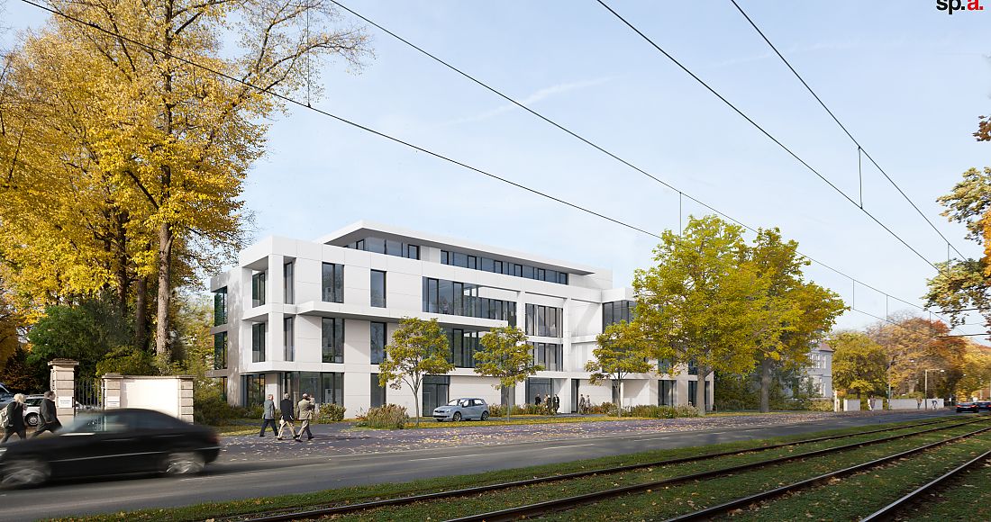 Foto: modernes, weißes Gebäude; Personen auf dem Gehweg,; Straßenbahnschienen im Vordergrund