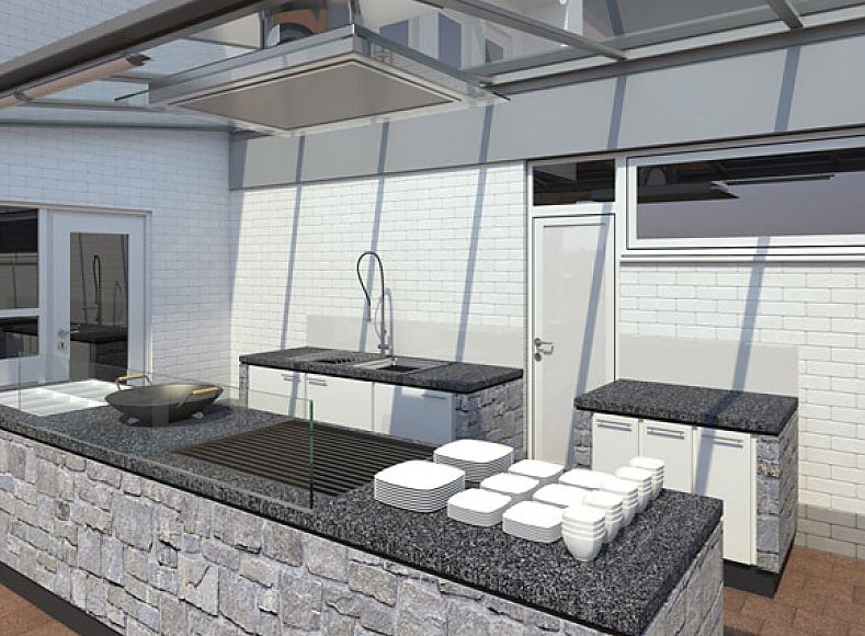Visualisierung: Nahaufnahme. Grillstation aus hellgrauem, unregelmäßig geformtem Naturstein mit dunkelgrauer Granit-Arbeitsfläche; gläserne Überdachung; zwei zusätzliche kleine Arbeitsflächen mit eingebautem Stauraum an der Rückwand; weiße Tür mittig; Waschbecken auf der linken Seite; umliegendes Gebäude aus weißem Stein