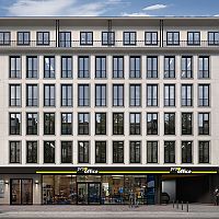 Mehrstöckiges Bürogebäude mit großen Fenstern und 'pro office' Geschäft im Erdgeschoss